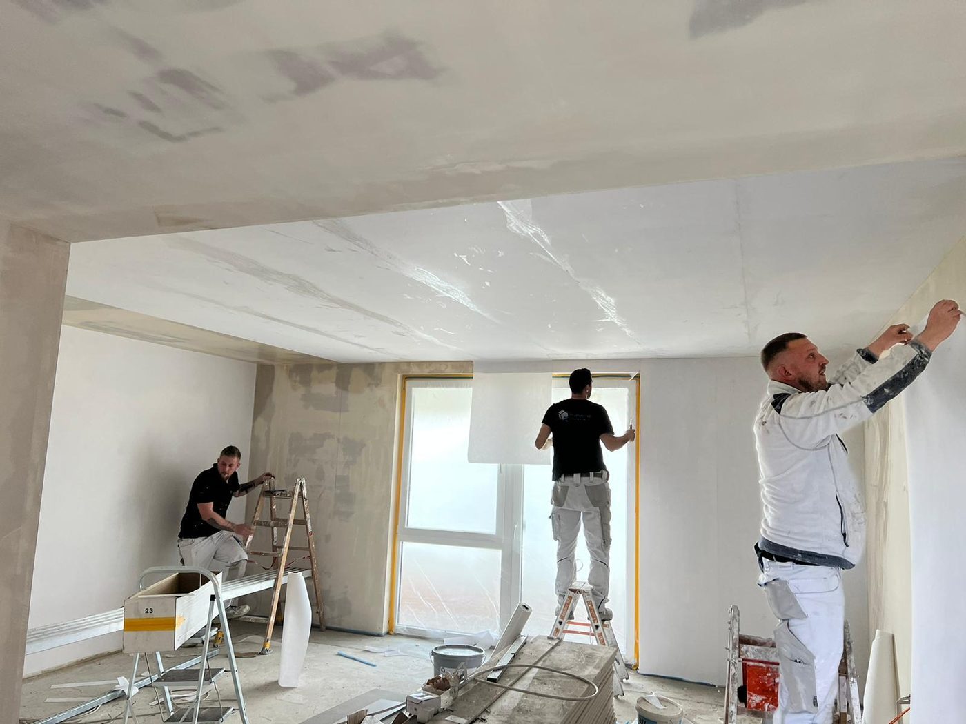Equipa a aplicar acabamento em teto