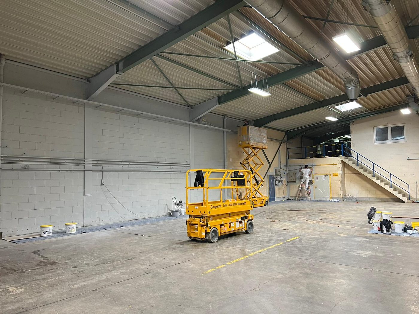 Nave industrial com plataforma elevatória durante a pintura